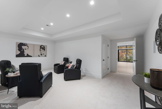 carpeted living room with a tray ceiling