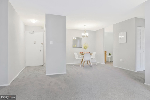 carpeted empty room featuring a notable chandelier