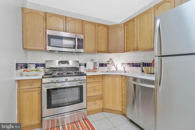 kitchen with appliances with stainless steel finishes, light brown cabinets, and light tile patterned flooring