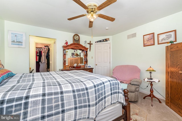 carpeted bedroom with a spacious closet, a closet, and ceiling fan