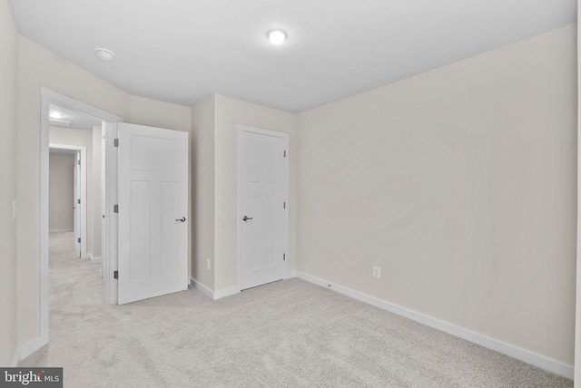 unfurnished bedroom featuring light carpet