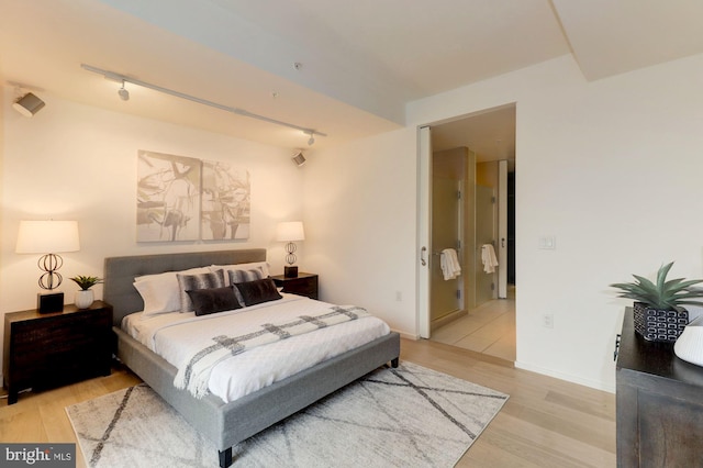 bedroom featuring track lighting and light hardwood / wood-style flooring