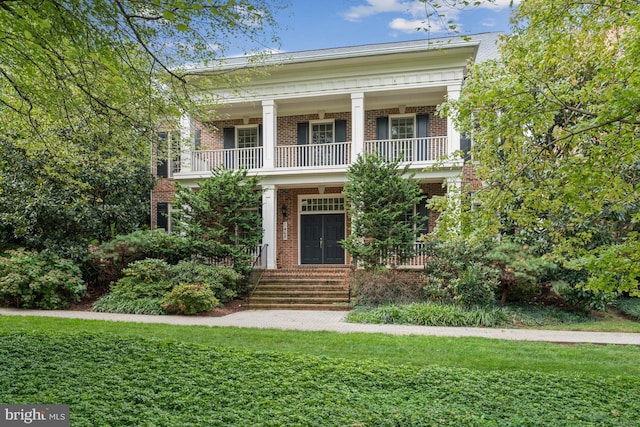 greek revival house with a porch and a front lawn