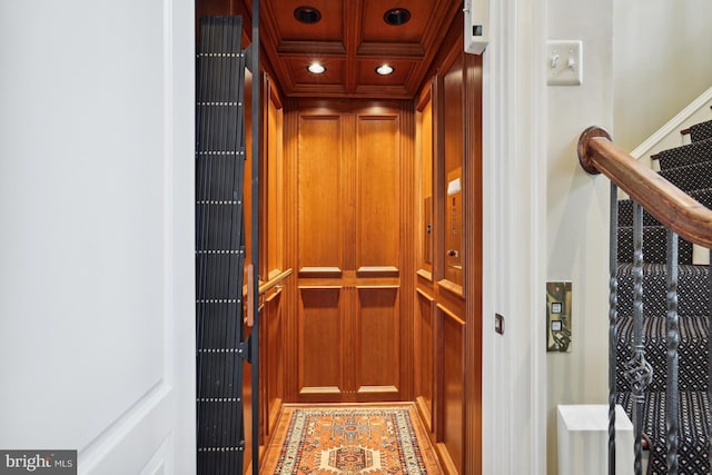 details featuring wooden ceiling, coffered ceiling, crown molding, elevator, and wooden walls