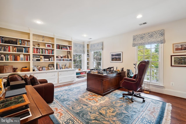 office area featuring built in shelves and hardwood / wood-style floors