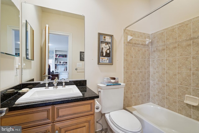 full bathroom featuring toilet, vanity, and tiled shower / bath