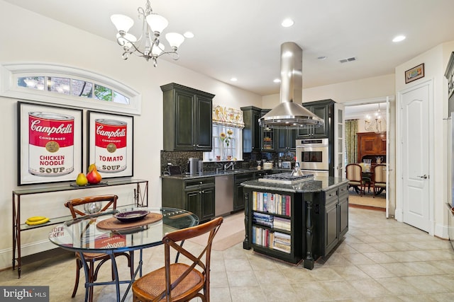 kitchen with a center island, dark stone countertops, appliances with stainless steel finishes, island exhaust hood, and a chandelier