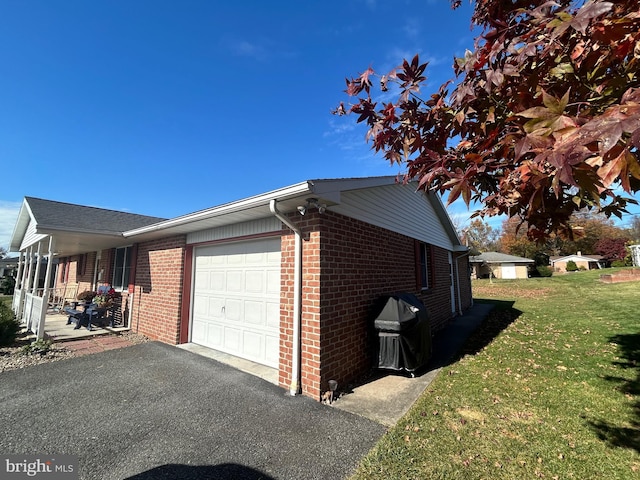 view of side of home featuring a garage and a lawn