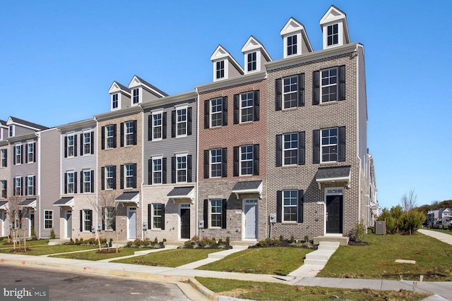 view of property with a front lawn and central AC unit