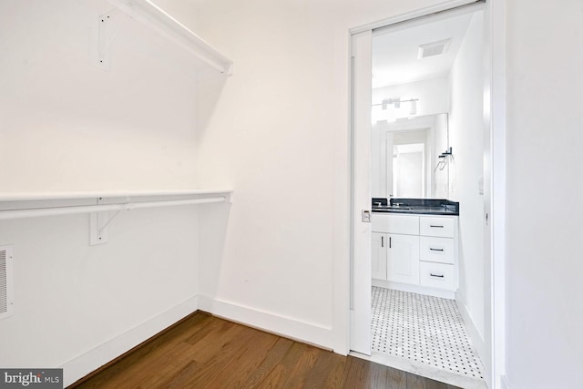 walk in closet with dark hardwood / wood-style floors and sink