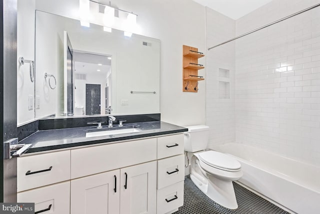 full bathroom with tile patterned flooring, vanity, tiled shower / bath combo, and toilet