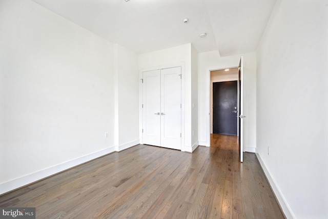 unfurnished bedroom with a closet and hardwood / wood-style floors