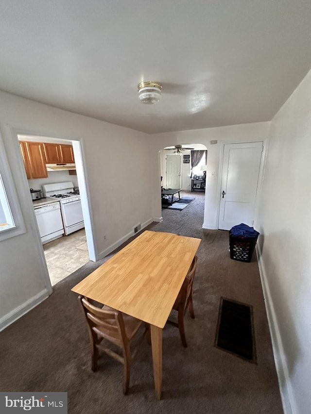 carpeted dining room featuring ceiling fan