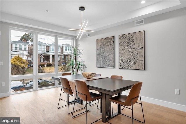 dining area featuring a notable chandelier and light wood-type flooring