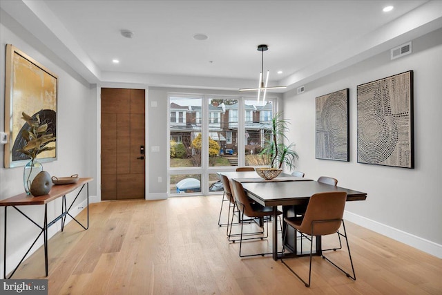 dining room with an inviting chandelier and light wood-type flooring