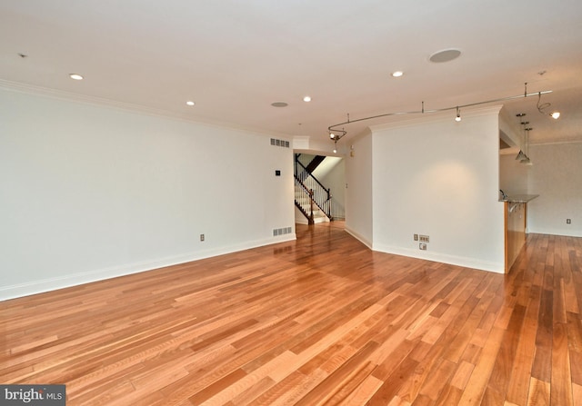 spare room with crown molding and light hardwood / wood-style flooring