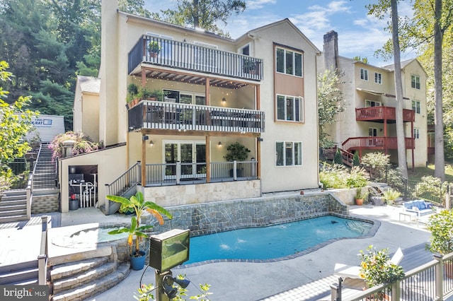 back of house featuring pool water feature