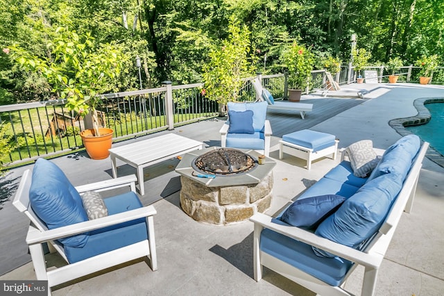 view of patio / terrace with a fenced in pool and an outdoor living space with a fire pit