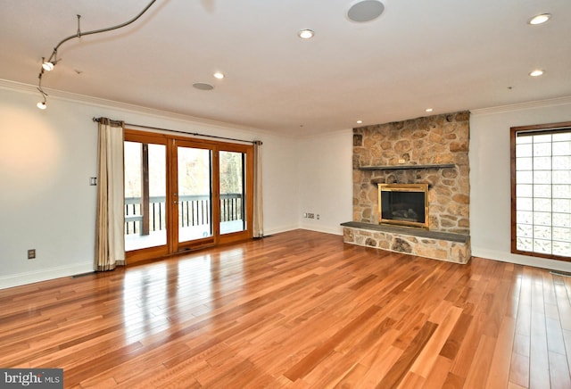 unfurnished living room with light hardwood / wood-style floors, ornamental molding, and a fireplace