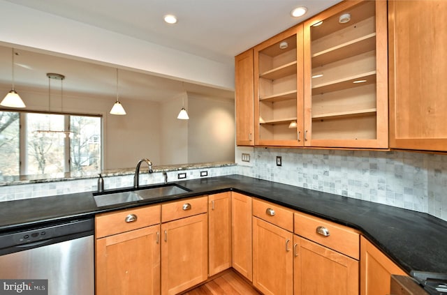 kitchen with backsplash, stainless steel dishwasher, hanging light fixtures, and sink