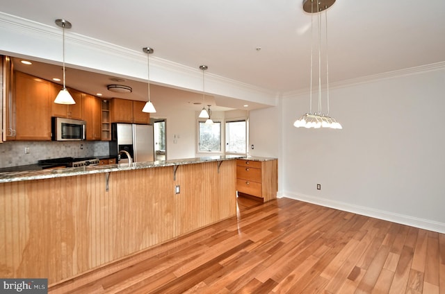 kitchen featuring a kitchen bar, tasteful backsplash, hanging light fixtures, and stainless steel appliances