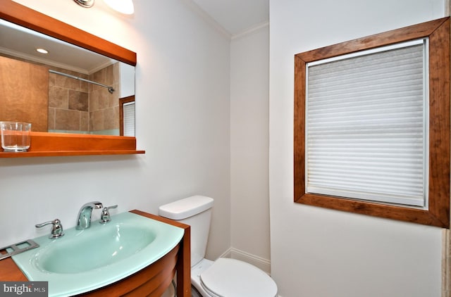 bathroom with vanity, toilet, and ornamental molding