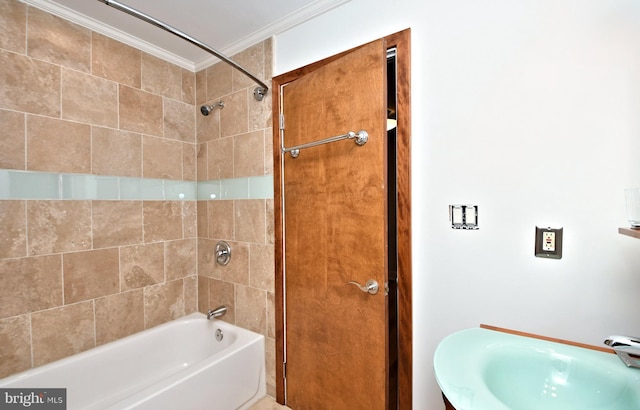 bathroom with crown molding, sink, and tiled shower / bath combo