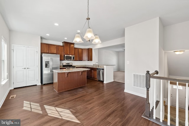 kitchen with dark hardwood / wood-style flooring, sink, decorative light fixtures, and appliances with stainless steel finishes