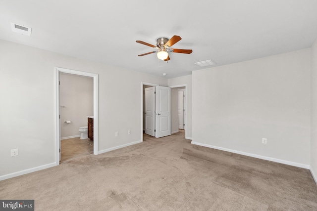 unfurnished bedroom featuring ensuite bathroom, light carpet, and ceiling fan