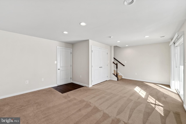 basement with a wealth of natural light and light colored carpet