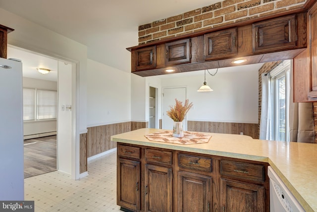 kitchen with light wood-type flooring, decorative light fixtures, wooden walls, a baseboard radiator, and white appliances