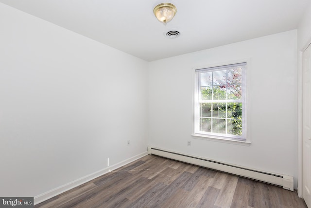 unfurnished room featuring hardwood / wood-style floors and a baseboard radiator