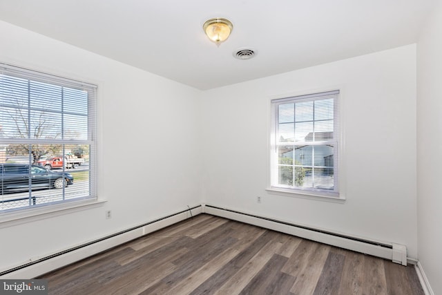 spare room with a baseboard heating unit and hardwood / wood-style flooring