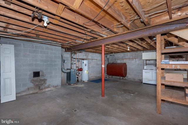 basement featuring electric water heater and washer / dryer