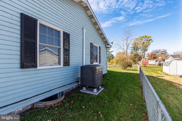 view of side of property with cooling unit, a lawn, and a storage shed