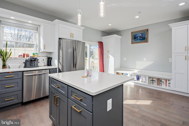 kitchen featuring white cabinets, appliances with stainless steel finishes, gray cabinets, and hanging light fixtures