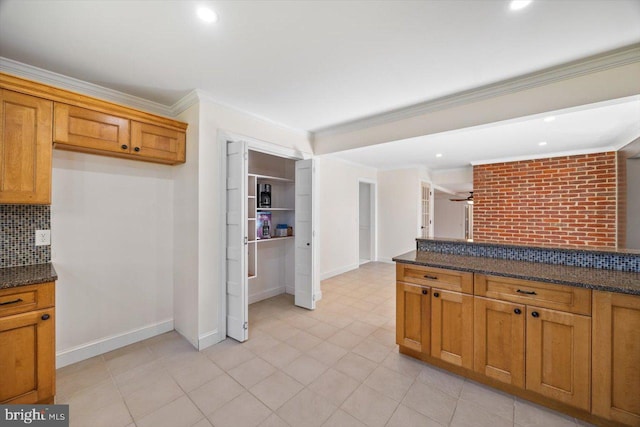 kitchen featuring crown molding, ceiling fan, dark stone countertops, and tasteful backsplash