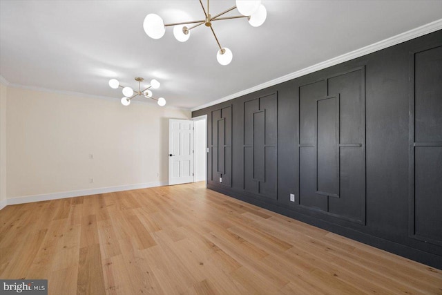 unfurnished room with crown molding, a chandelier, and light hardwood / wood-style floors