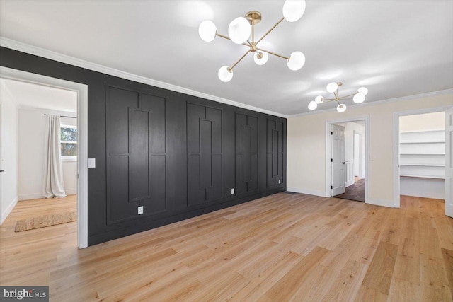 unfurnished bedroom with light hardwood / wood-style floors, an inviting chandelier, and ornamental molding