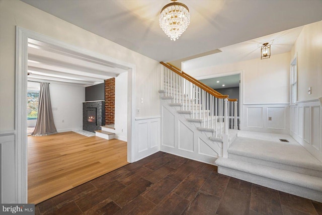 stairway with hardwood / wood-style floors and a chandelier