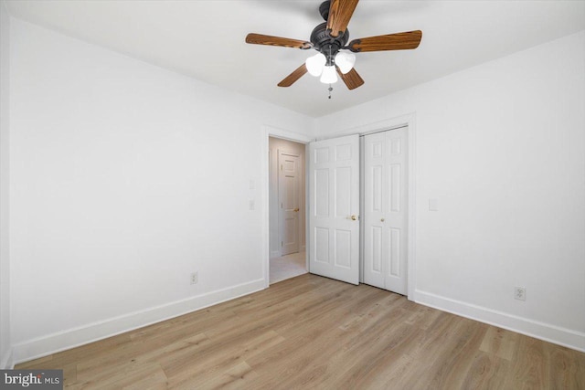 unfurnished bedroom featuring a closet, light wood-type flooring, and ceiling fan