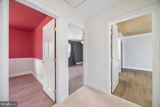 corridor featuring ornamental molding and light wood-type flooring