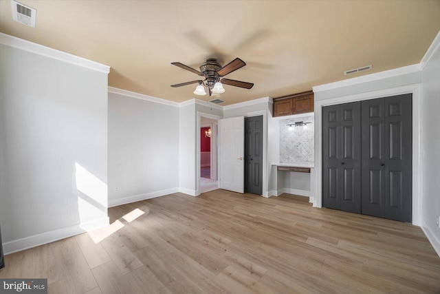 unfurnished bedroom with ceiling fan, ornamental molding, and light wood-type flooring