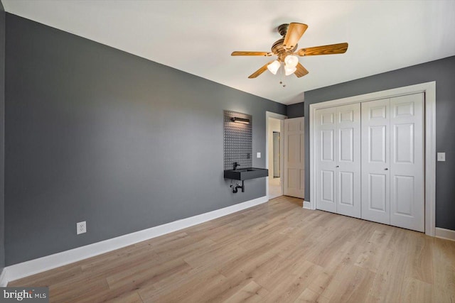 unfurnished bedroom featuring light hardwood / wood-style floors, a closet, and ceiling fan