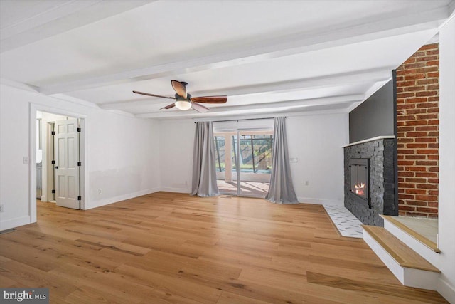 unfurnished living room featuring ceiling fan, beam ceiling, and hardwood / wood-style floors