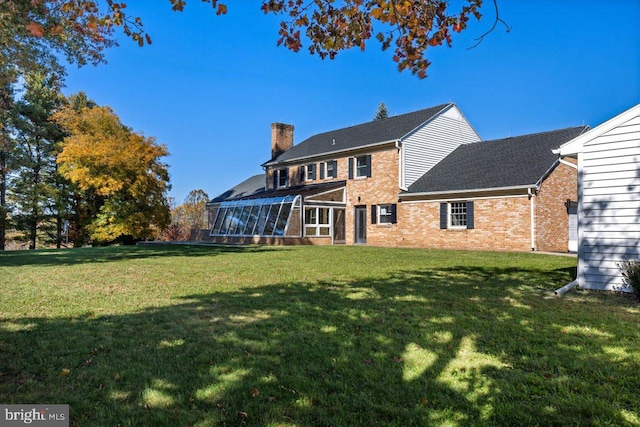 rear view of property with a yard