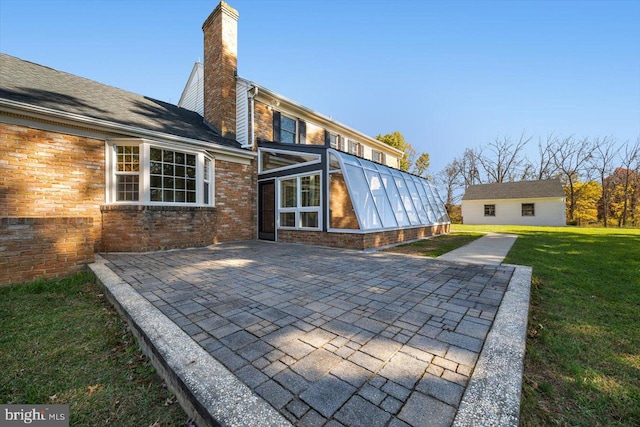 rear view of property featuring a yard and a patio area