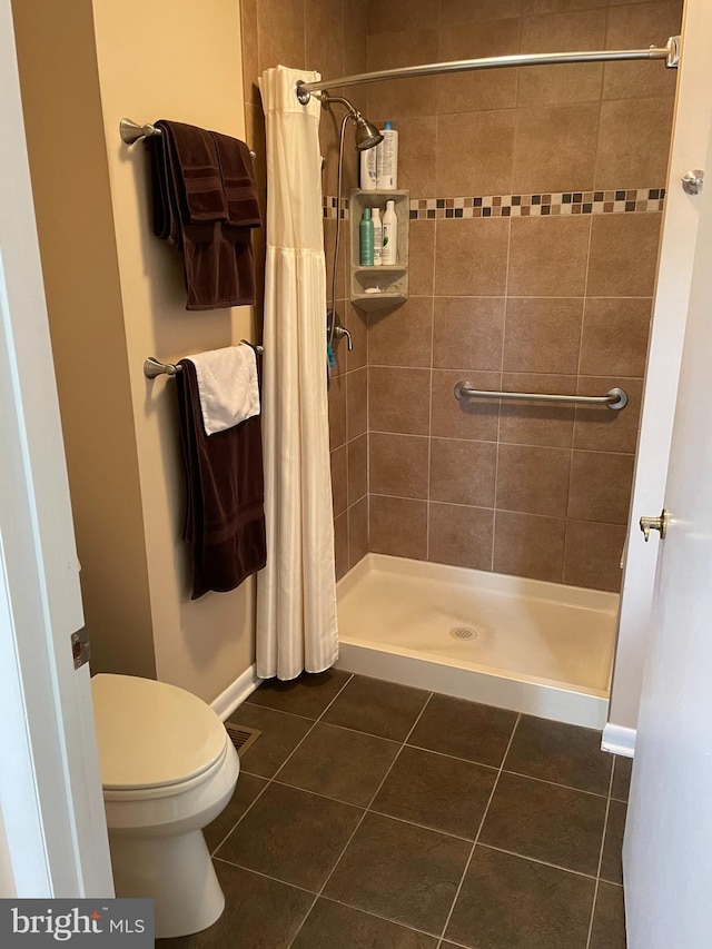 bathroom featuring toilet, walk in shower, and tile patterned floors