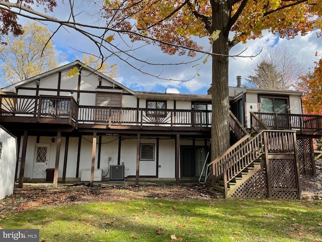 back of property featuring a wooden deck, a lawn, and central AC unit