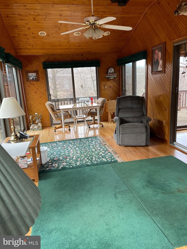 living room with vaulted ceiling, wood-type flooring, and a healthy amount of sunlight